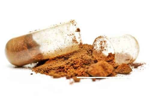 Herbal powder spilling from an open capsule
