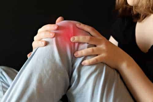 Hands holding a painful knee