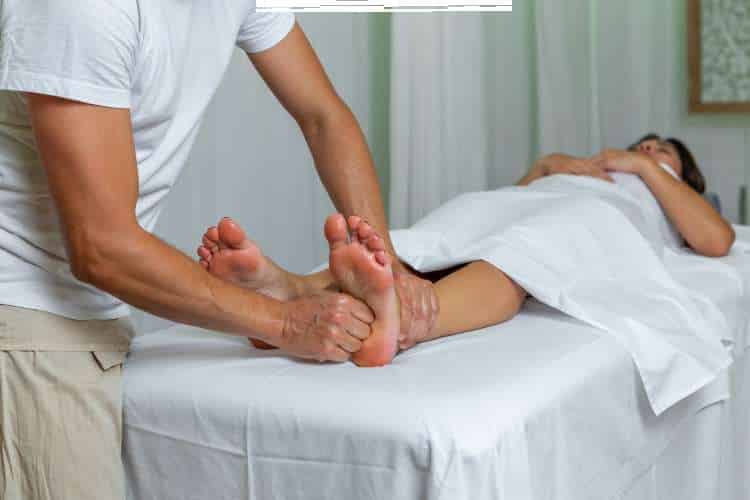 Therapist massaging a patient’s foot and lower leg