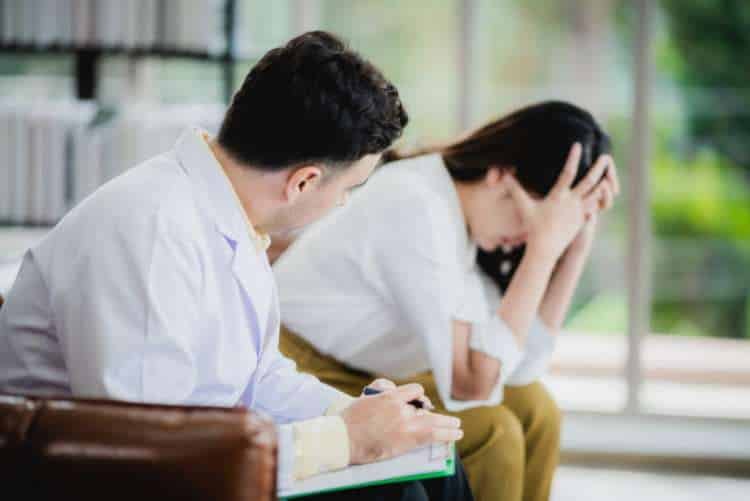 Man comforting a distressed woman in a counselling session