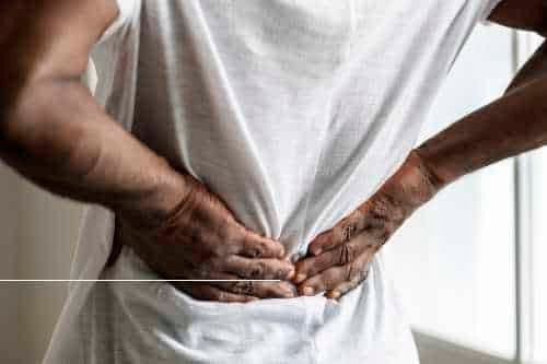 Man pressing both hands into his lower back