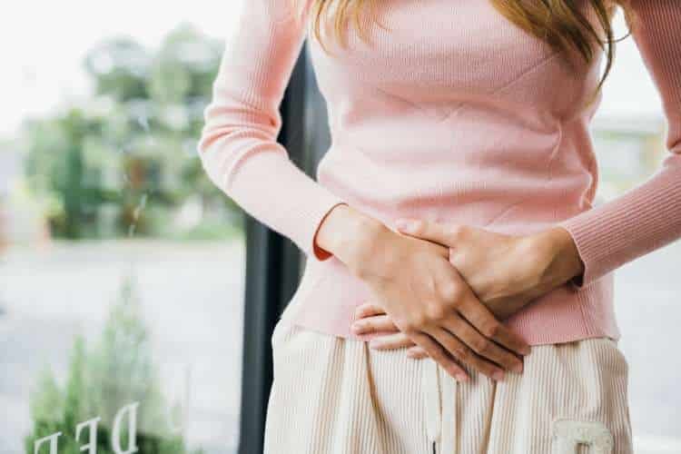 Woman holding her stomach with both hands
