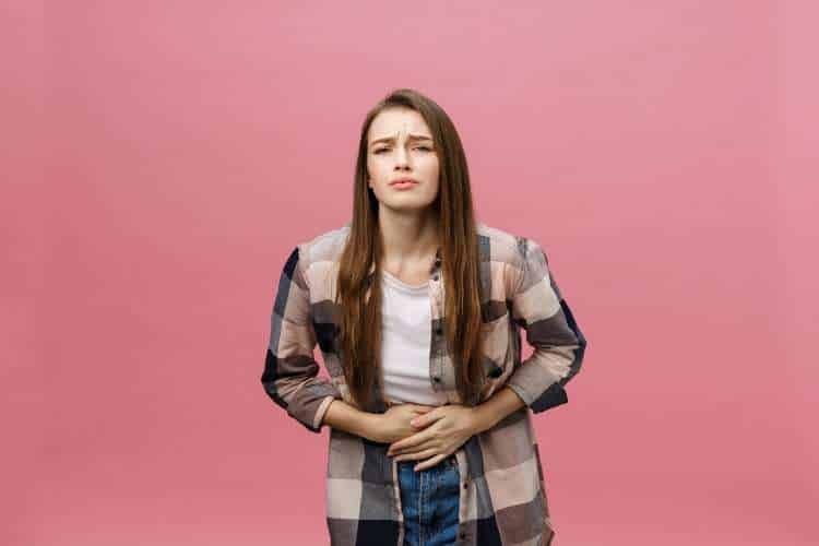 Young woman holding her stomach in discomfort