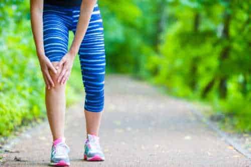 Runner on a trail holding their knee