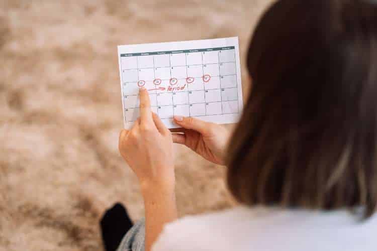 Woman holding a calendar with dates circled
