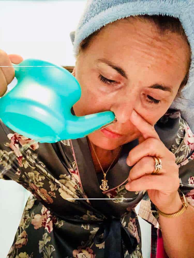 Woman using a neti pot to rinse her sinuses