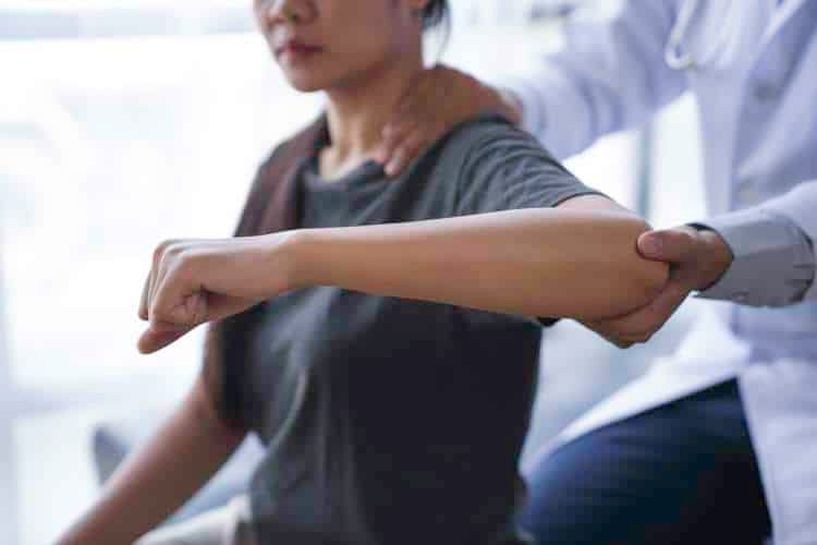 Practitioner checking a patient’s arm and shoulder